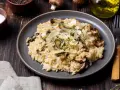 Kremowe risotto z pieczarkami, posypane parmezanem i ziołami.