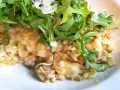 Kremowe risotto z kurczakiem i pieczarkami, udekorowane rukolą i parmezanem.