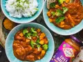 Dwa talerze z sosem Tikka Masala, ryżem, brokułami i dynią, obok słoik sosu.