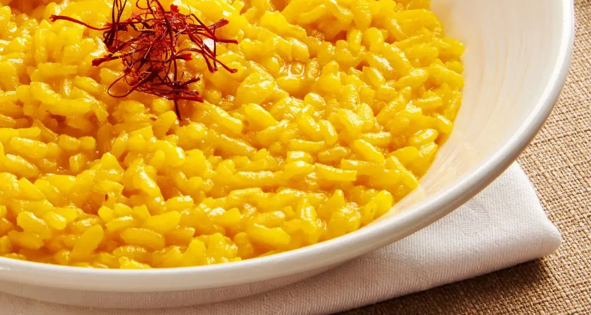 Miseczka kremowego risotto alla Milanese, ozdobiona nitkami szafranu.