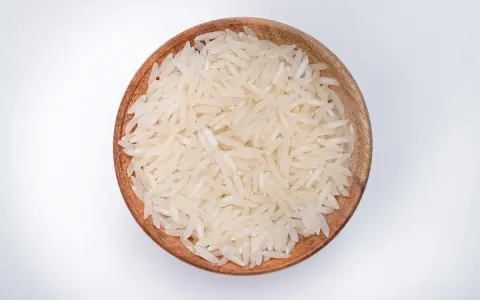 Miseczka z ryżem parboiled na białym tle.
