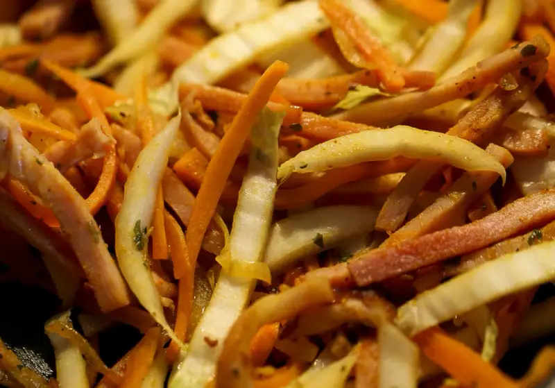 Pokrojone w słupki marchewka, fasolka i inne warzywa w daniu stir-fry.